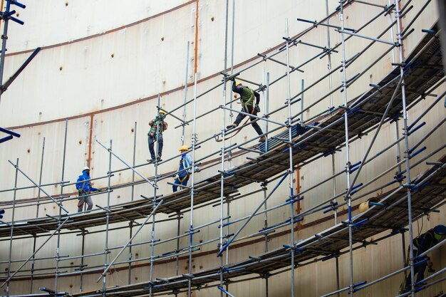Workers installing safety nets at a construction site for fall protection.